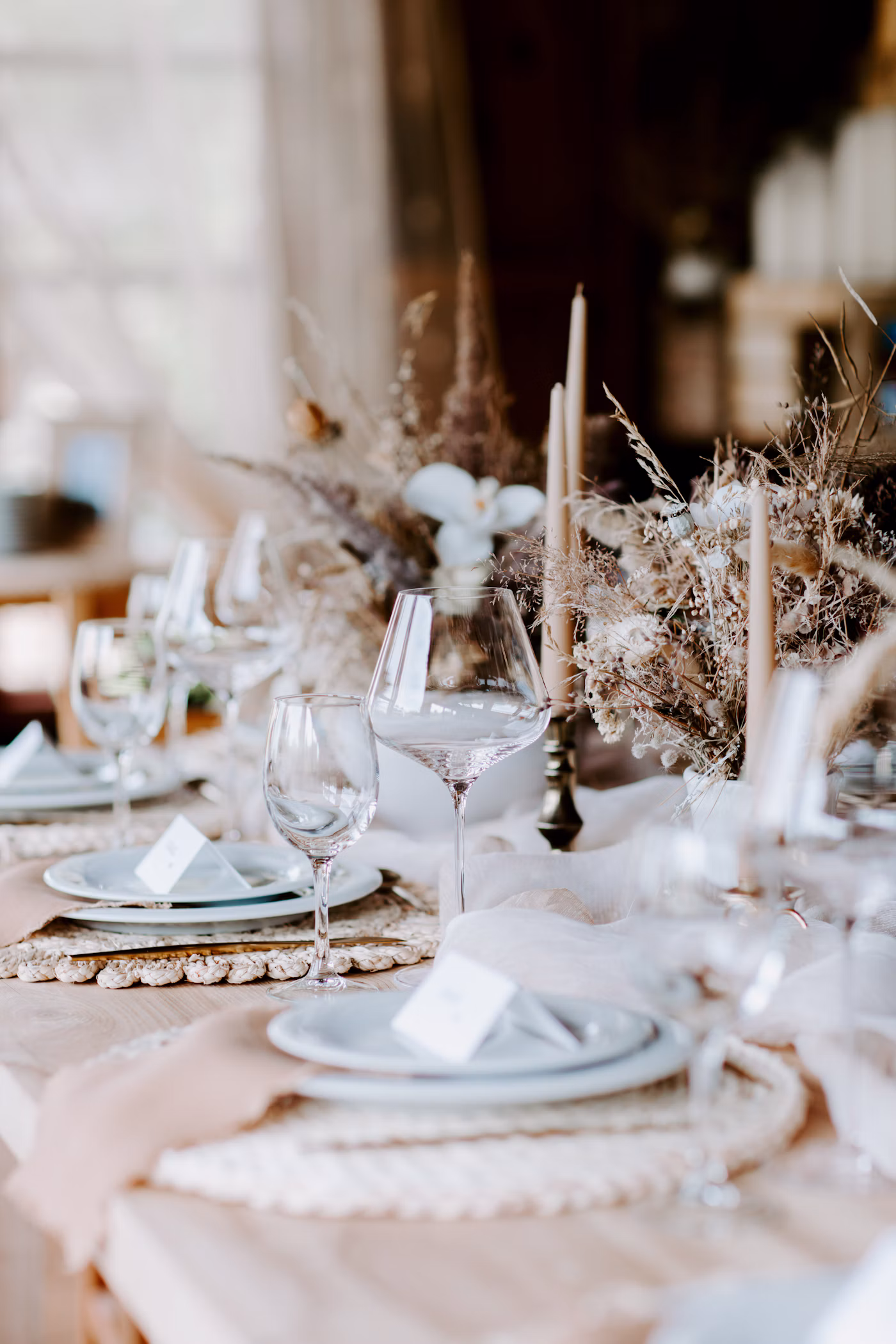 Fine-art wedding tablescape with custom place settings, taper candles, and seasonal florals
